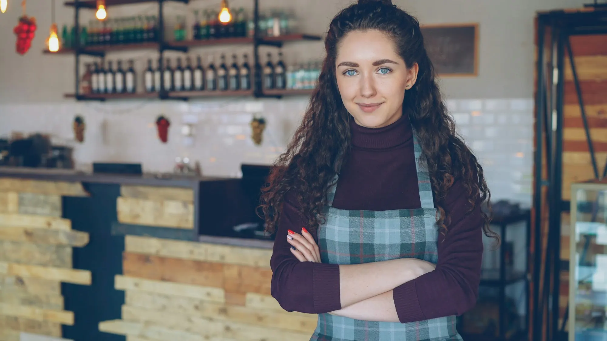 The owner of a coffee shop standing behind her counter